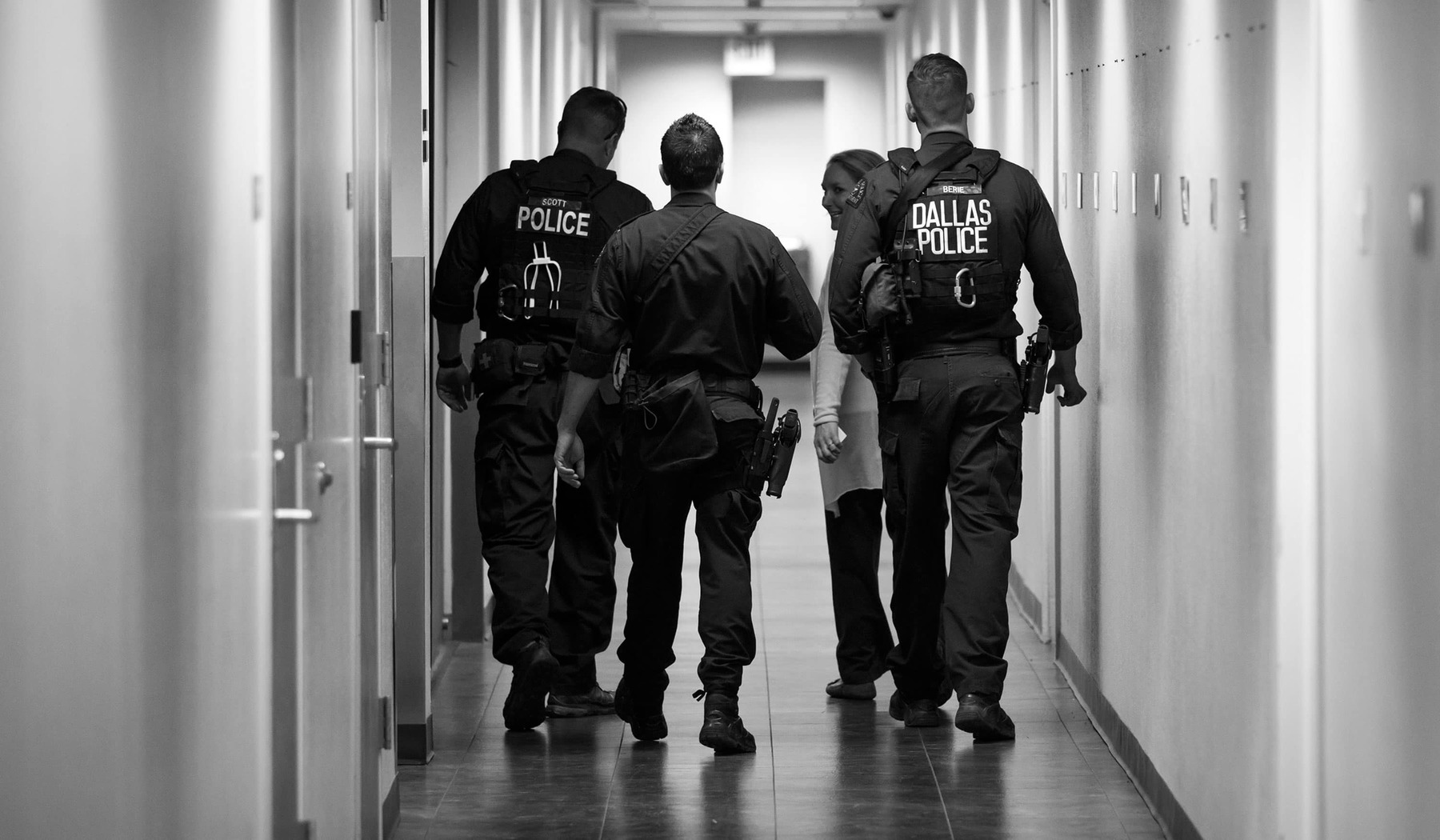 Author Jamie Thompson walks with members of the Dallas SWAT team